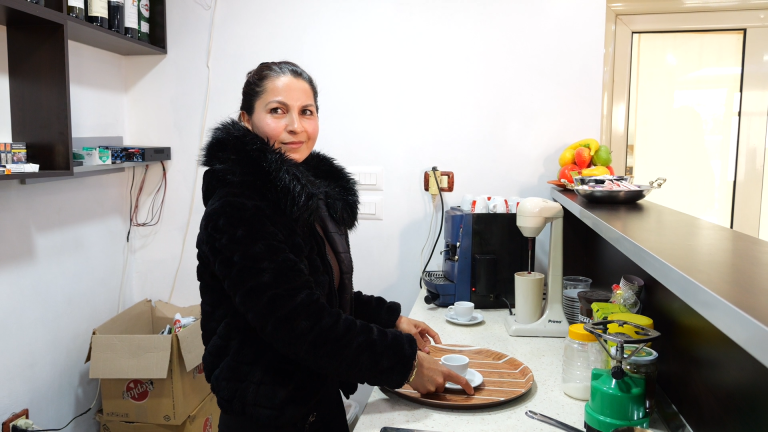 woman in black jumper serving a coffee